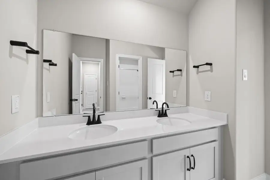 The secondary bath features tile flooring, white cabinetry and light countertops and a shower/tub combo. Perfect for accommodating any visiting family and friends.