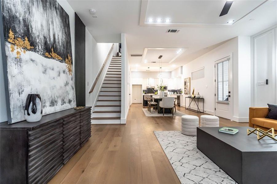 Corner view of the first floor, shoing the living, stairs, dining, and kitchen areas. The open-space layout provides ample room for hosting parties and gatherings, ensuring an easy flow throughout the house.