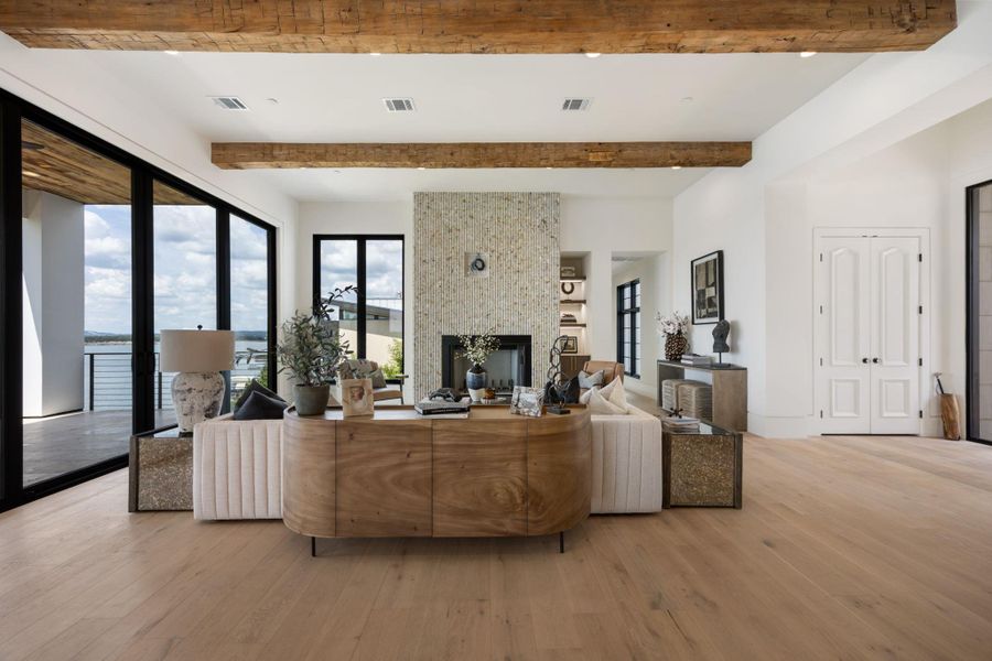 Natural light illuminates this spacious living area with hardwood flooring and a fireplace, offering a stunning water view. Natural light illuminates this spacious living area with hardwood flooring and a fireplace, offering a stunning water view.