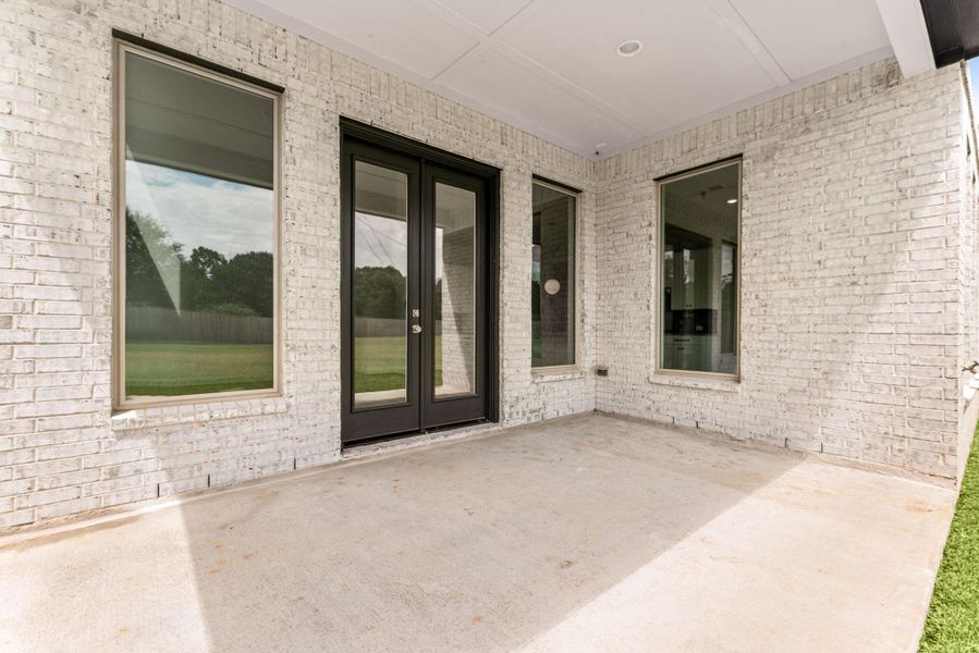 A covered back patio, framed in the same brick as the rest of the exterior, offers a shaded spot right off the kitchen for morning coffee or an evening dinner outside A covered back patio, framed in the same brick as the rest of the exterior, offers a shaded spot right off the kitchen for morning coffee or an evening dinner outside