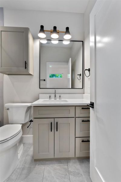 Contemporary primary bathroom vanity featuring light gray cabinetry, white countertop, and integrated sink Contemporary primary bathroom vanity featuring light gray cabinetry, white countertop, and integrated sink