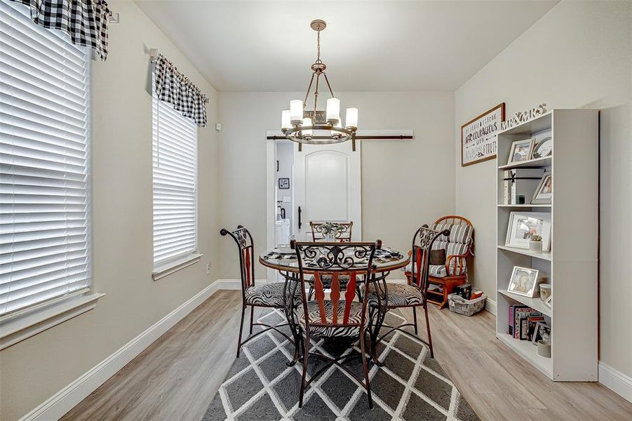 Dining space with a notable chandelier and light wood-type flooring