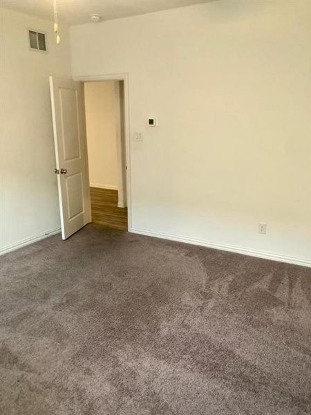 Empty room with dark carpet and baseboards Empty room with dark carpet and baseboards