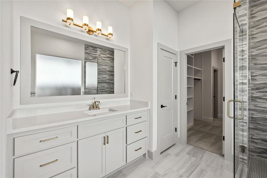 Bathroom with vanity, a shower stall, a walk in closet, and light marble finish flooring
