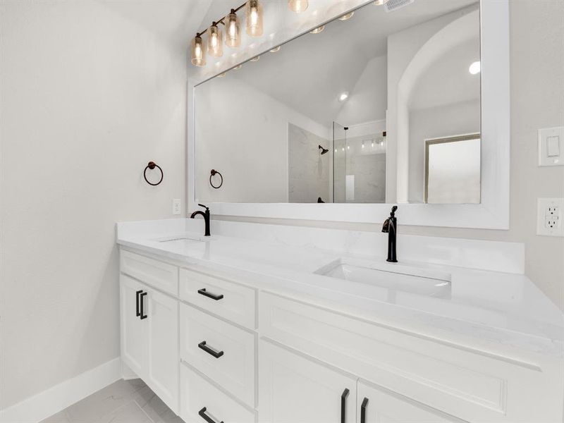 Bathroom with double vanity and a marble finish shower