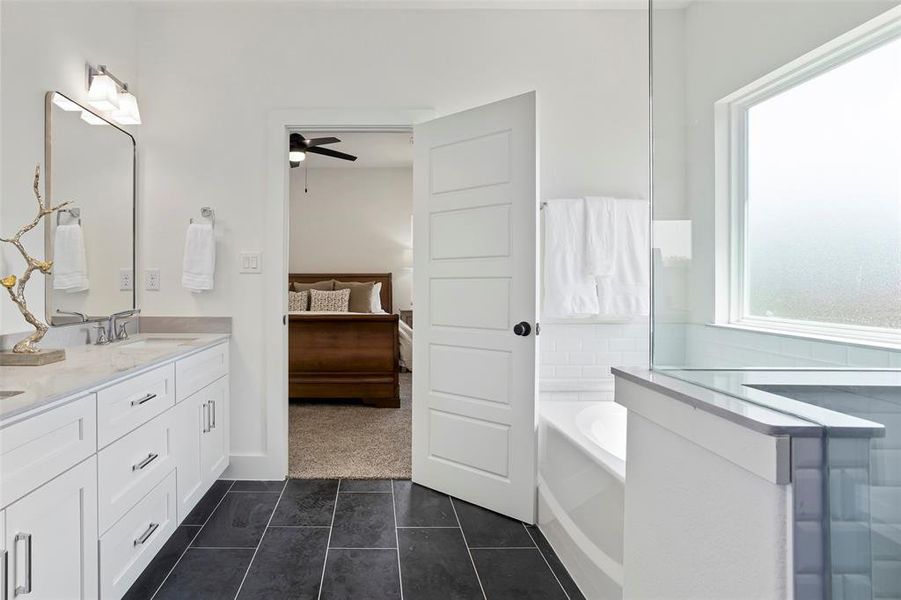 Bathroom with a bath, ceiling fan, tile floors, and double sink vanity