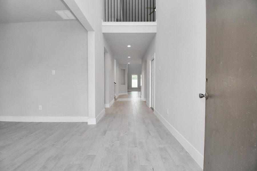 As you step into the threshold of this luxurious home, you'll soon be welcomed by an elegant glass door (to be installed). Inside, soaring ceilings amplify the spaciousness, while the refined wood-look tile flooring and oversized baseboards exude sophistication and charm. Sample photo of completed home with similar floor plan. Actual colors and selections may vary. As you step into the threshold of this luxurious home, you'll soon be welcomed by an elegant glass door (to be installed). Inside, soaring ceilings amplify the spaciousness, while the refined wood-look tile flooring and oversized baseboards exude sophistication and charm. Sample photo of completed home with similar floor plan. Actual colors and selections may vary.