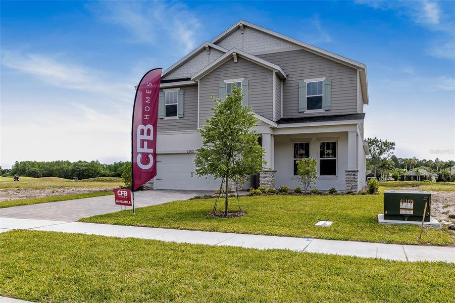 Front exterior of a new home in Gray Hawk at Hole Two, Daytona Beach, FL, highlighting curb appeal (Image 32). Front exterior of a new home in Gray Hawk at Hole Two, Daytona Beach, FL, highlighting curb appeal (Image 32).