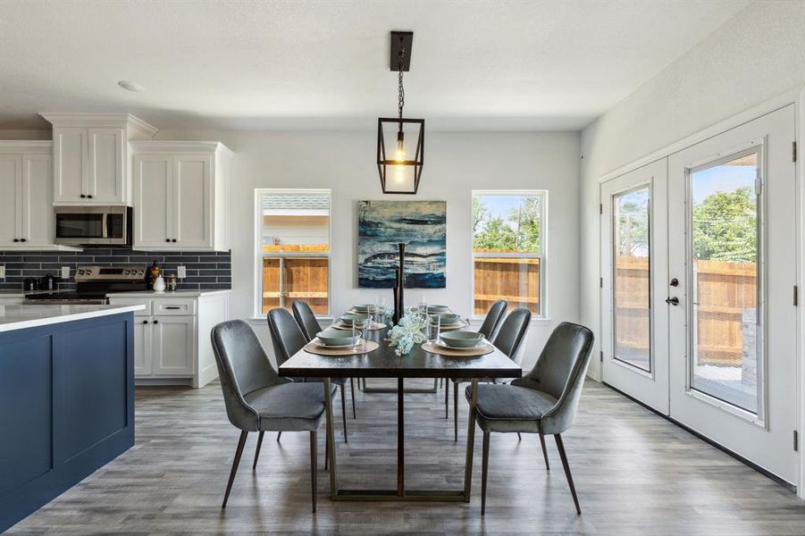 Dining room with a wealth of natural light, hardwood / wood-style flooring, and french doors