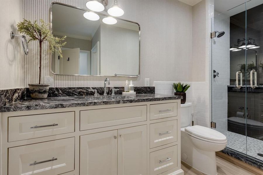 Bathroom featuring hardwood / wood-style flooring, vanity, toilet, and a shower with shower door