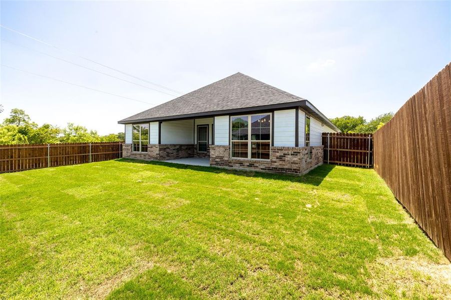 Rear view of house with a yard and a patio