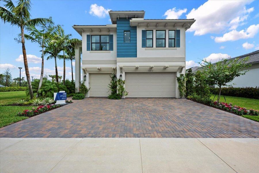 Front exterior of a new home in Apex at Avenir, Palm Beach Gardens, FL, highlighting curb appeal (Image 1).