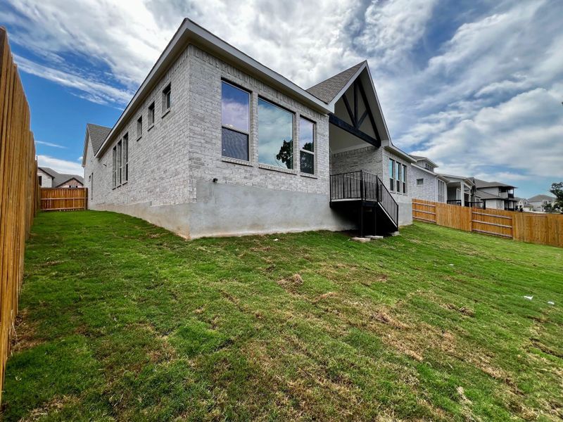 Rear view of house featuring a fenced backyard, brick siding, and a patio area Rear view of house featuring a fenced backyard, brick siding, and a patio area