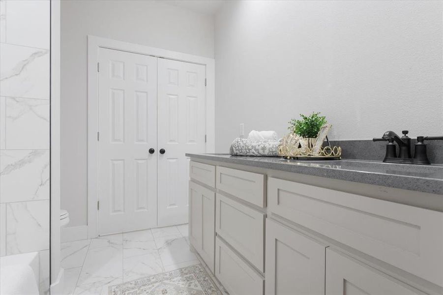 Bathroom featuring tile floors, vanity, and toilet