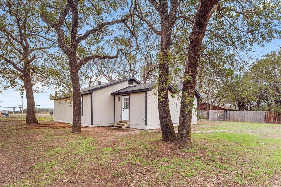 Rear view of house featuring entry steps and roof with shingles