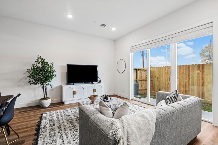 This stylish living room features warm LVP flooring, a neutral color palette, and an open-concept layout perfect for relaxation and entertaining.