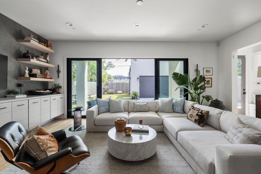 The spacious family room offers light hardwood floors, a flexible layout for multiple furniture arrangements, wiring for sound, and an open connection to the kitchen and dining areas for easy everyday living.