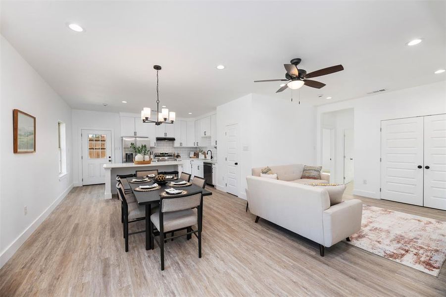 Dining room with light wood finished floors, recessed lighting, a chandelier, and ceiling fan Dining room with light wood finished floors, recessed lighting, a chandelier, and ceiling fan
