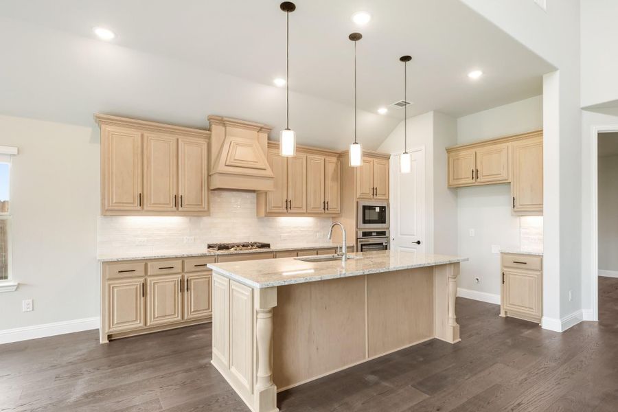 Kitchen with light wood cabinets, large island with granite countertop, and dark hardwood floors Kitchen with light wood cabinets, large island with granite countertop, and dark hardwood floors