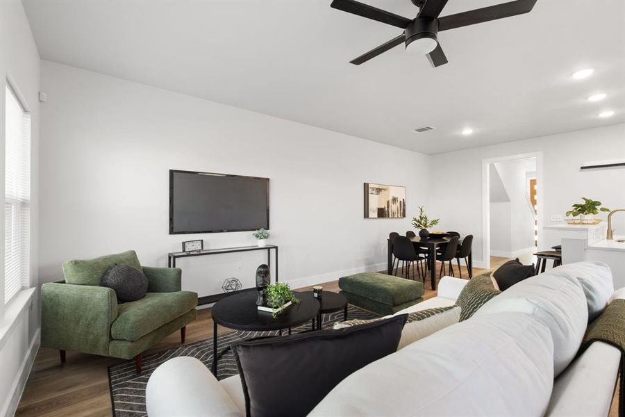 Living room featuring baseboards, visible vents, a ceiling fan, wood finished floors, and recessed lighting