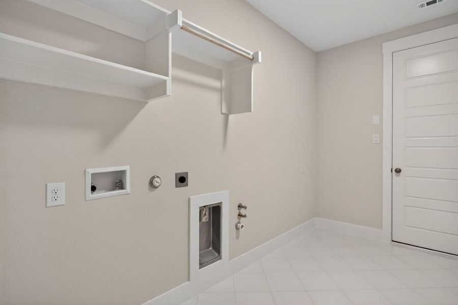 Utility room featuring light neutral wall paint, white trim, white shelving, an integrated hanging rod, and diagonal tile flooring Utility room featuring light neutral wall paint, white trim, white shelving, an integrated hanging rod, and diagonal tile flooring
