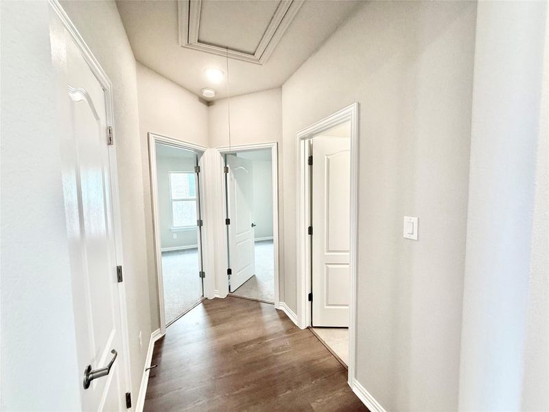 Hall featuring attic access and dark wood-style floors Hall featuring attic access and dark wood-style floors