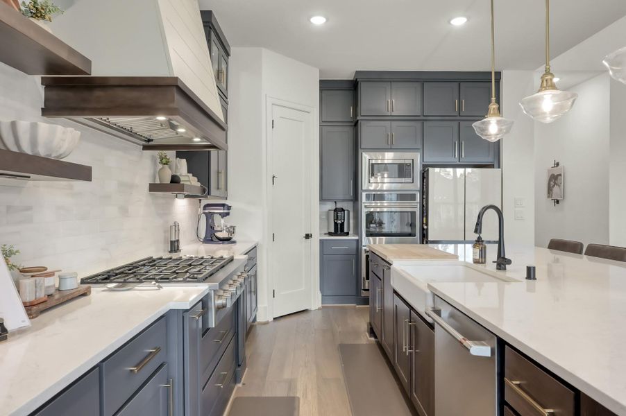 Quartz countertops and abundant cabinetry create a beautiful and practical cooking space. A gas cooktop and convection oven make preparing meals both efficient and enjoyable.