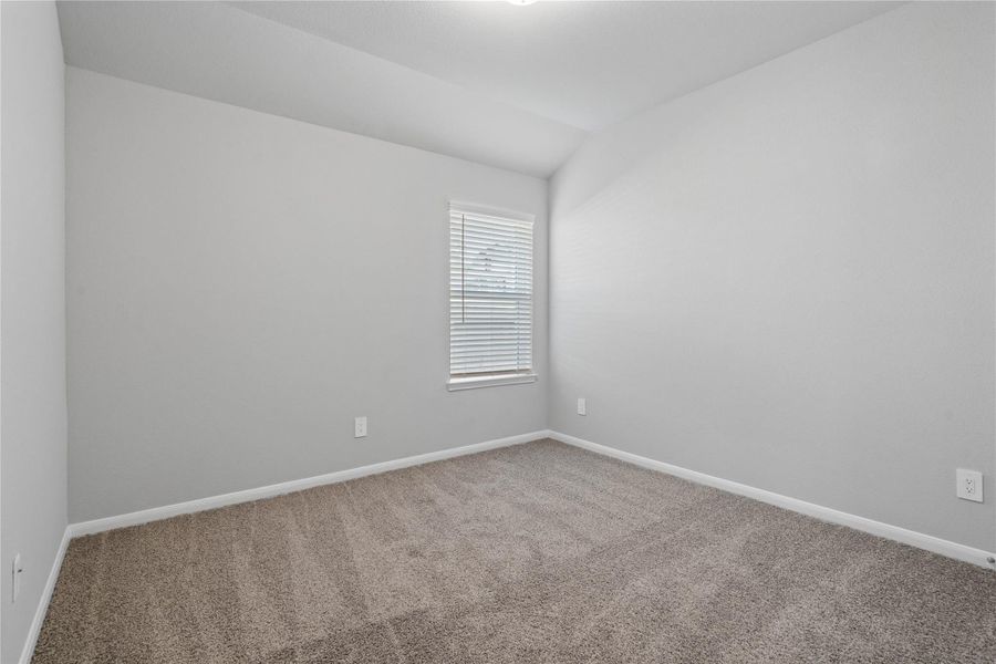 Perfect for guests or a quiet home office, this room features soft plush carpeting, a window with fitted blinds, sloped ceiling, and ample sized closet space. Perfect for guests or a quiet home office, this room features soft plush carpeting, a window with fitted blinds, sloped ceiling, and ample sized closet space.