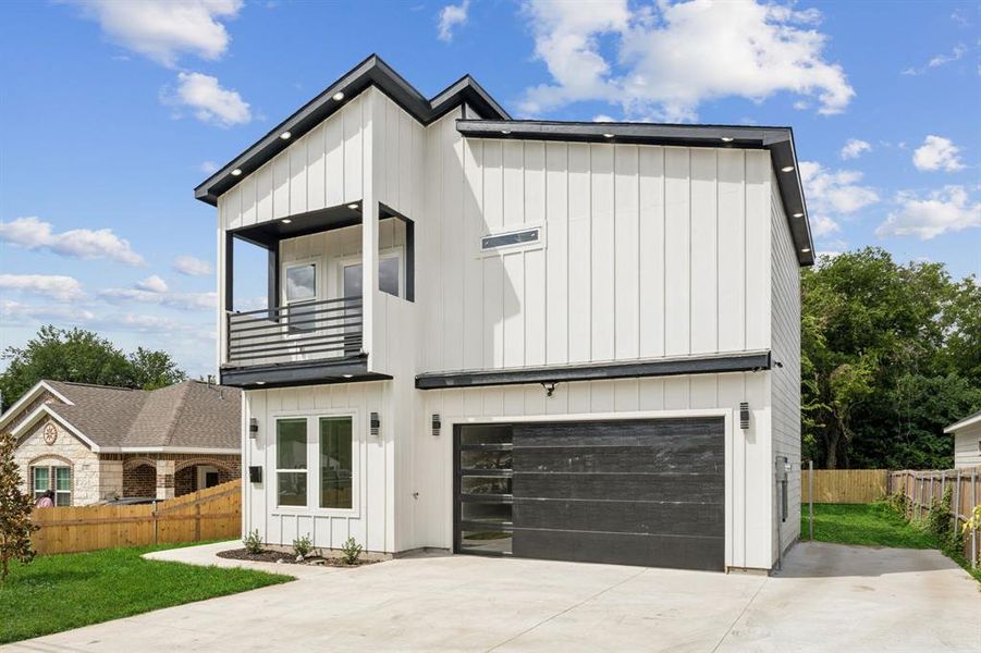 View of front facade with a balcony and a garage