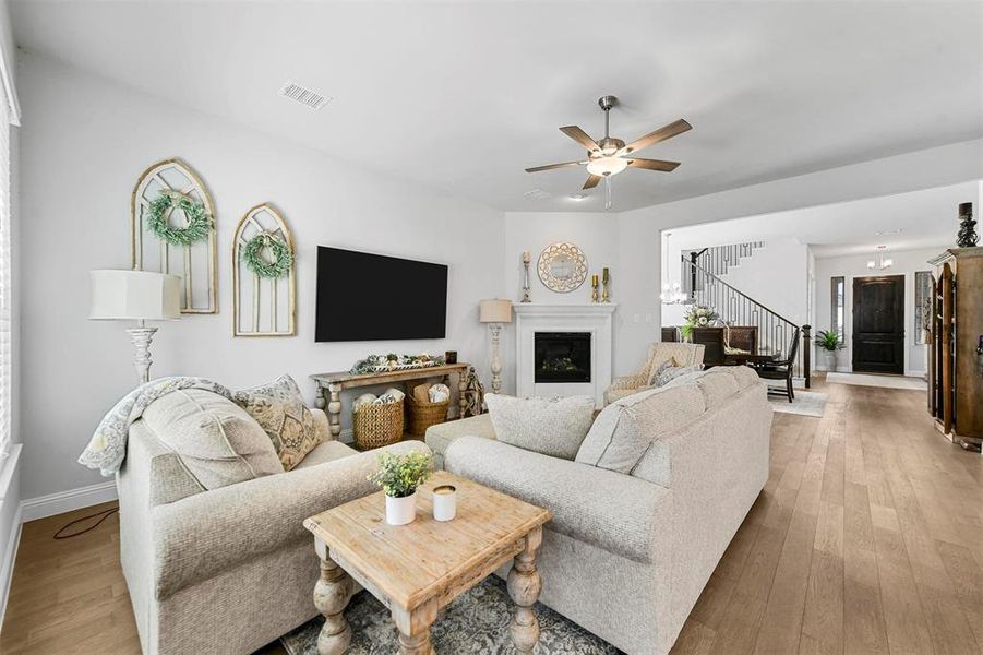 Living room with ceiling fan and light hardwood / wood-style flooring