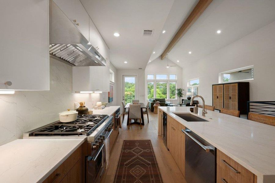 Streamlined kitchen design flows into a sun-drenched open concept living space. Streamlined kitchen design flows into a sun-drenched open concept living space.
