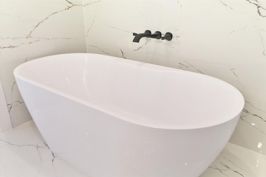 Relax in your luxurious soaking tub, complemented by a sleek wall-mounted modern faucet for a refined touch.