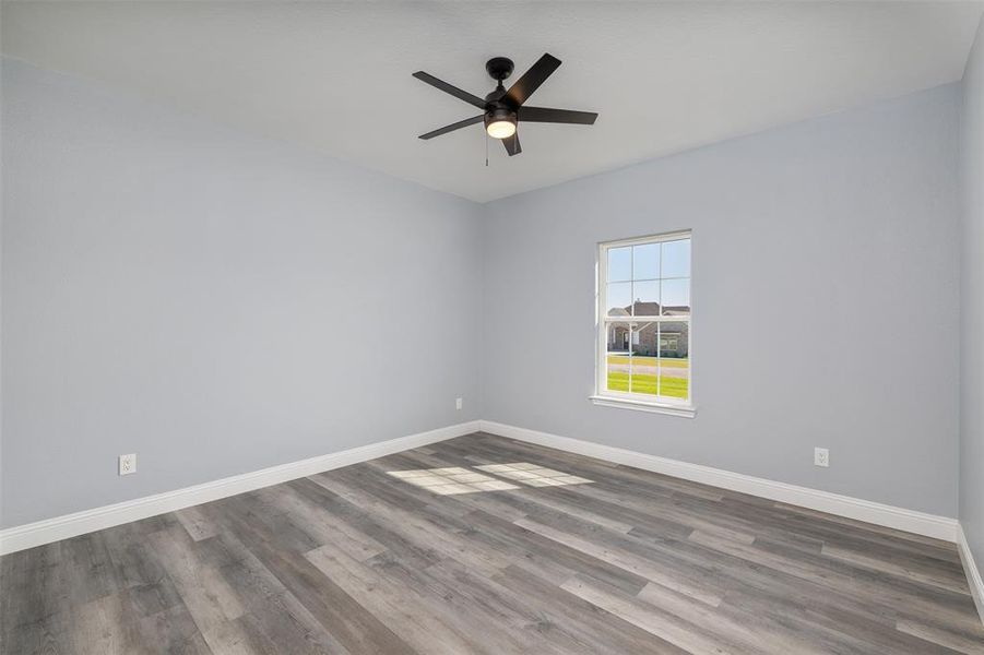 Unfurnished room with dark wood-type flooring and ceiling fan Unfurnished room with dark wood-type flooring and ceiling fan