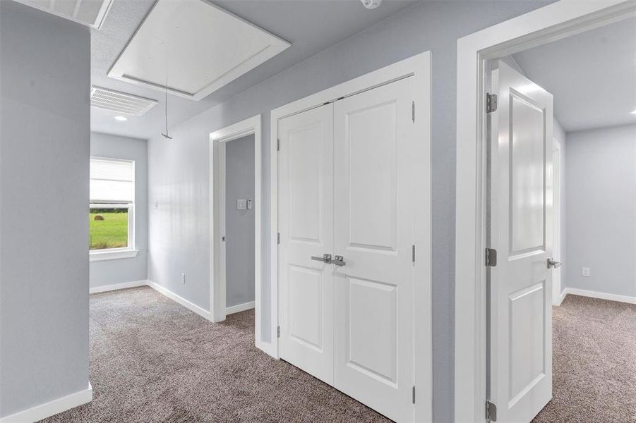 Hall featuring light colored carpet, attic access, and recessed lighting