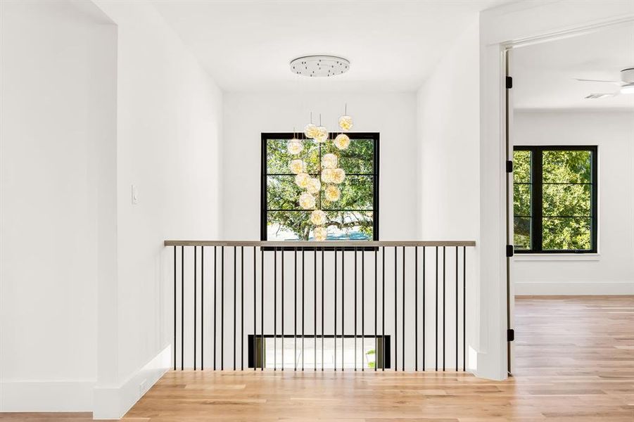 Hallway featuring wood finished floors and a chandelier Hallway featuring wood finished floors and a chandelier