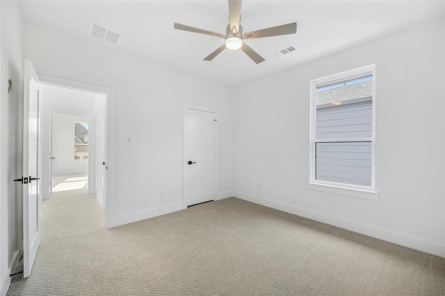 Unfurnished bedroom featuring light carpet, baseboards, and visible vents