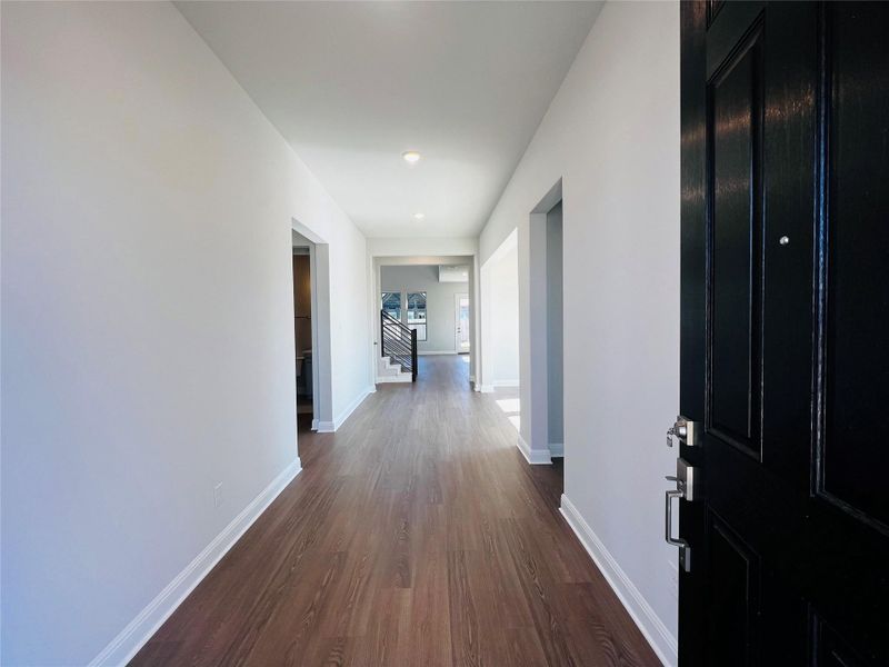 Hall with dark wood-style floors, stairs, and recessed lighting