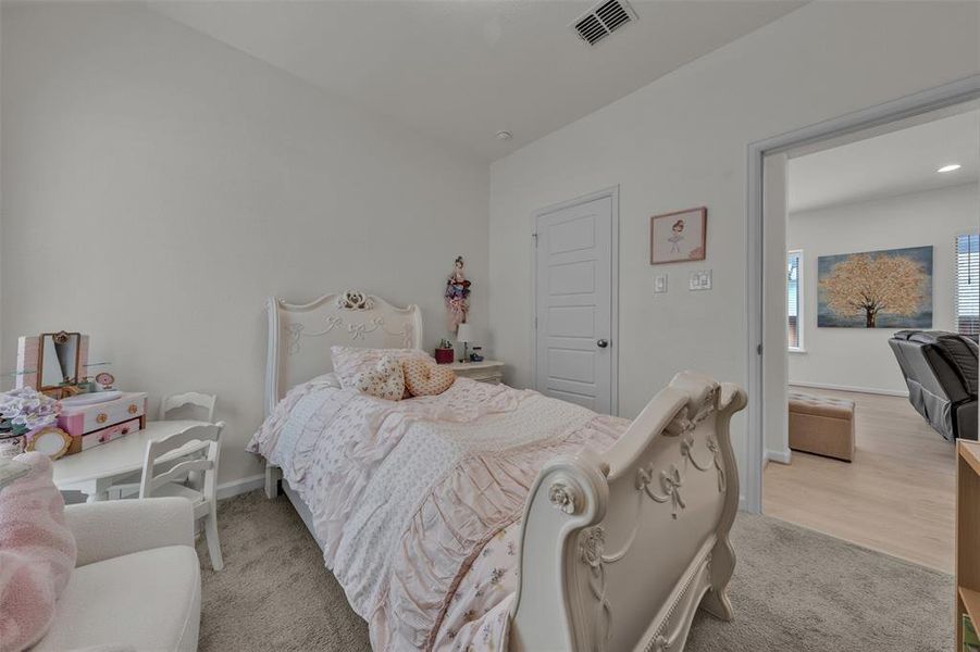 Carpeted interior room featuring a white paneled door, ceiling vent, and light-colored walls Carpeted interior room featuring a white paneled door, ceiling vent, and light-colored walls