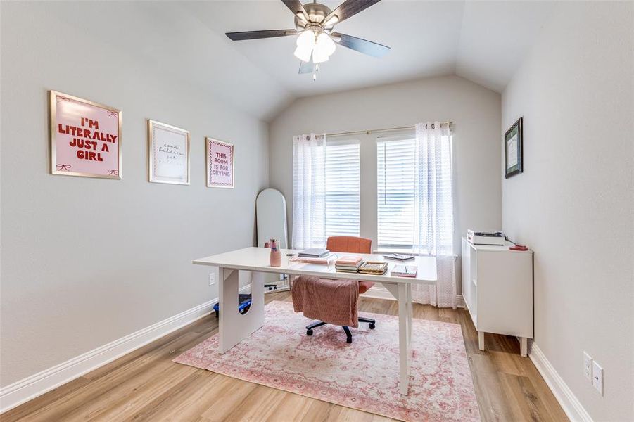 Office space featuring light wood-style flooring, vaulted ceiling, and a ceiling fan Office space featuring light wood-style flooring, vaulted ceiling, and a ceiling fan