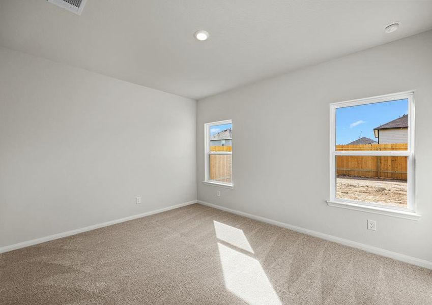 Windows let in plenty of natural light to this master bedroom.