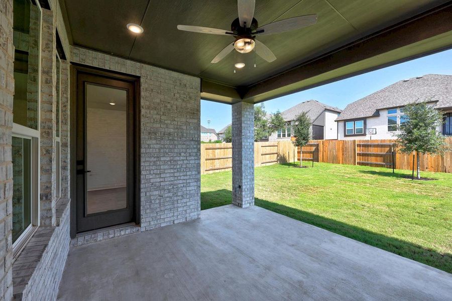 Fenced backyard with a ceiling fan, a patio area, and a residential view Fenced backyard with a ceiling fan, a patio area, and a residential view