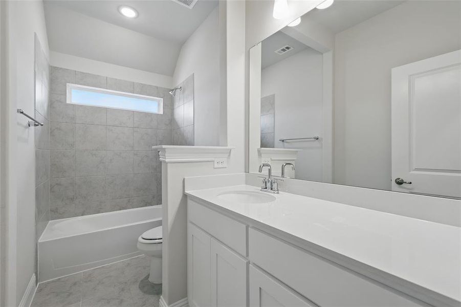 Bathroom featuring toilet, vanity, and bathing tub / shower combination Bathroom featuring toilet, vanity, and bathing tub / shower combination