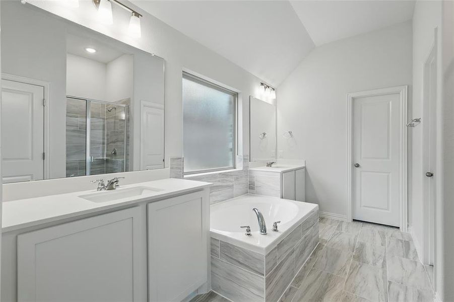 Full bathroom with a garden tub, marble finish floor, lofted ceiling, a shower stall, and a sink Full bathroom with a garden tub, marble finish floor, lofted ceiling, a shower stall, and a sink