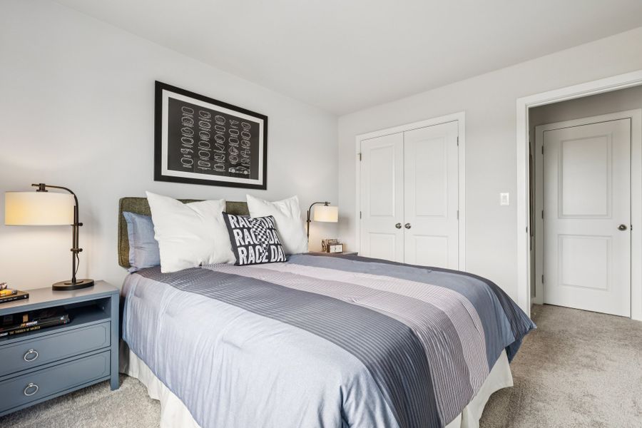 A bedroom with a bed and lamps.