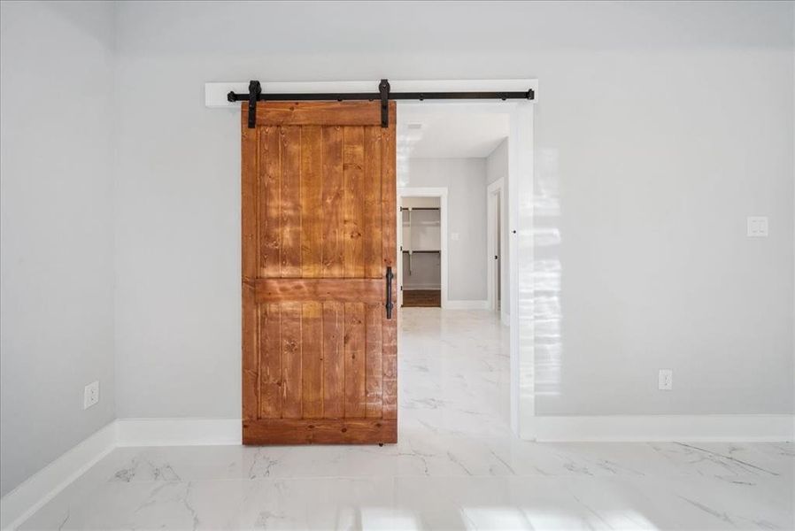 Unfurnished room with a barn door