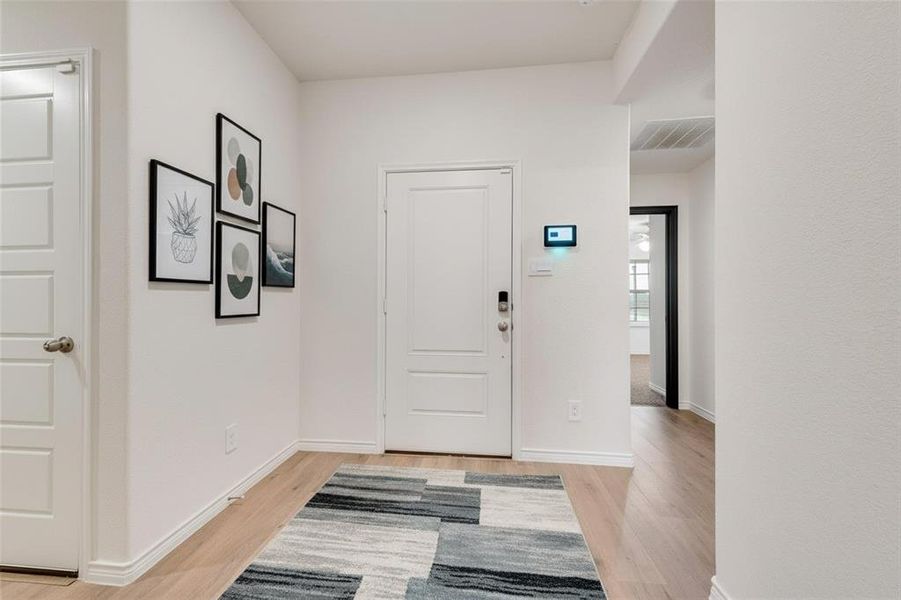 Foyer with light wood-style flooring and baseboards