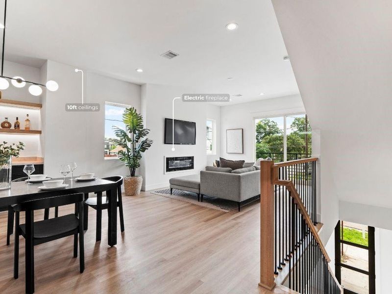 As you come up to the second floor, you’re greeted by an open dining area with a built-in dry bar, flowing seamlessly into the spacious living room with an electric fireplace and balcony views.