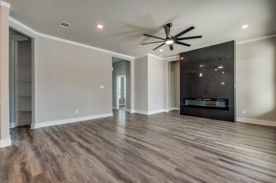 Unfurnished living room featuring a ceiling fan, wood finished floors, crown molding, and recessed lighting