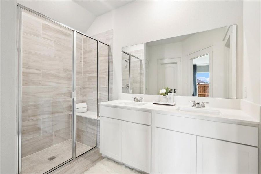 Full bathroom featuring a stall shower and double vanity