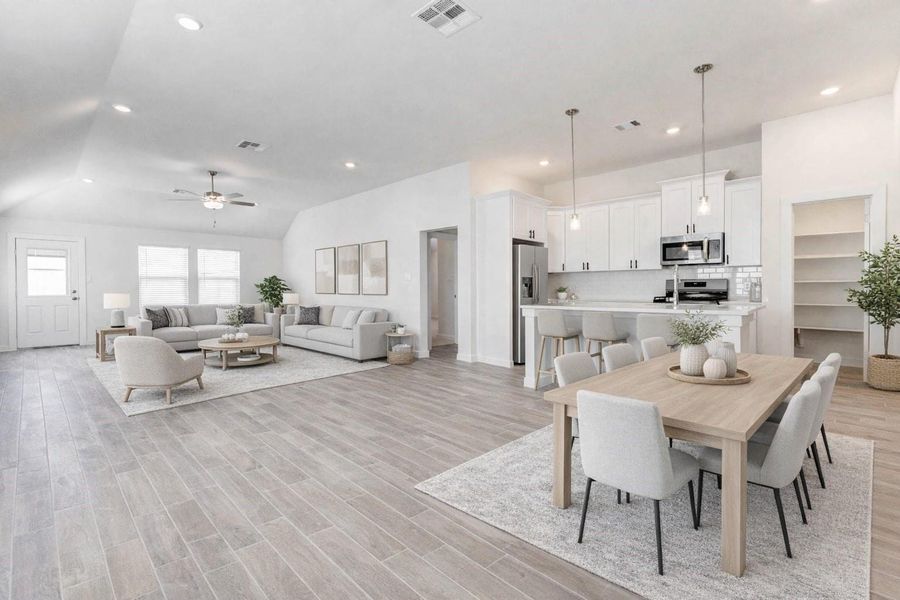 Seamlessly connected, the living room and kitchen create the ultimate open-concept experience. Sleek pendant lighting above the island, modern white cabinetry, and a walk-in pantry elevate the space, while the flowing floorplan offers comfort and functionality. This photo has been virtually staged for visual reference. Seamlessly connected, the living room and kitchen create the ultimate open-concept experience. Sleek pendant lighting above the island, modern white cabinetry, and a walk-in pantry elevate the space, while the flowing floorplan offers comfort and functionality. This photo has been virtually staged for visual reference.